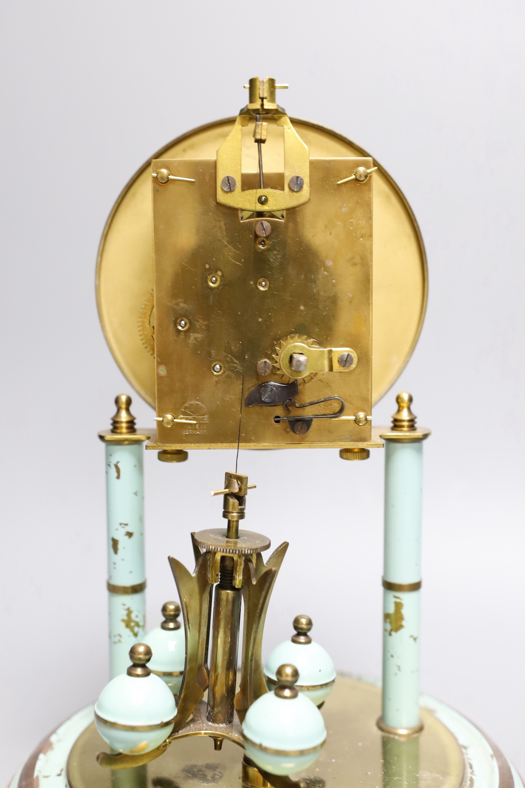 A German 400 day enamelled brass mantel timepiece, under a glass dome, 30cm total